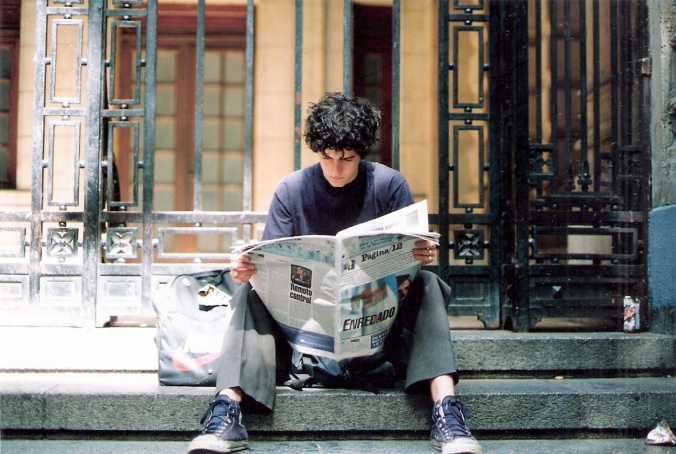 Un joven estudiante lee Página/12 en las escalinatas de su colegio secundario, en 2004